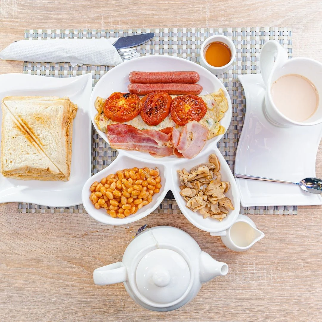 English breakfast with toast, eggs, sausage, baked beans and tea