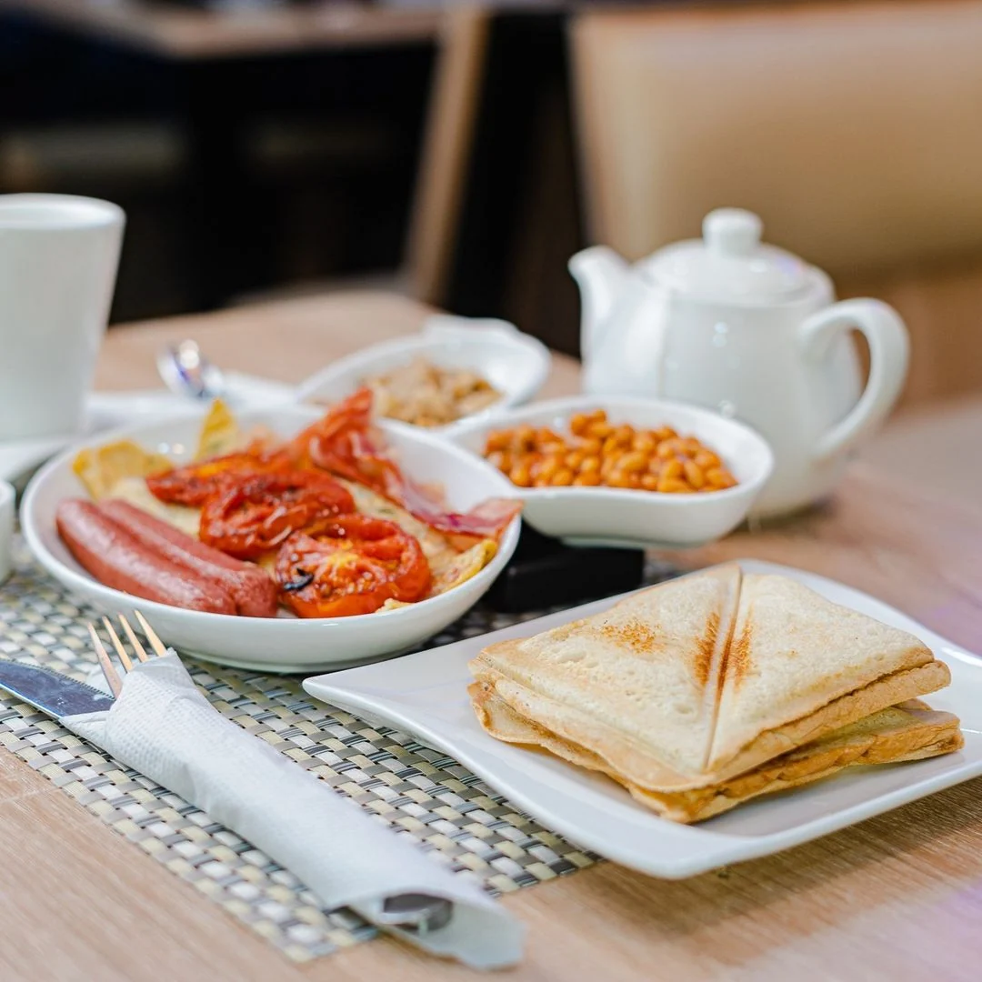 A breakfast spread with toast, baked beans and tea