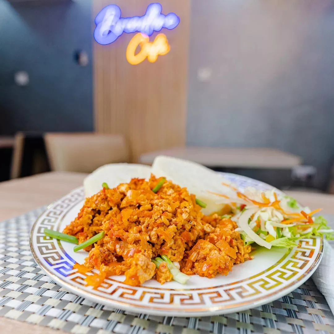 A plate of rice and chicken inside Breadline Cafe