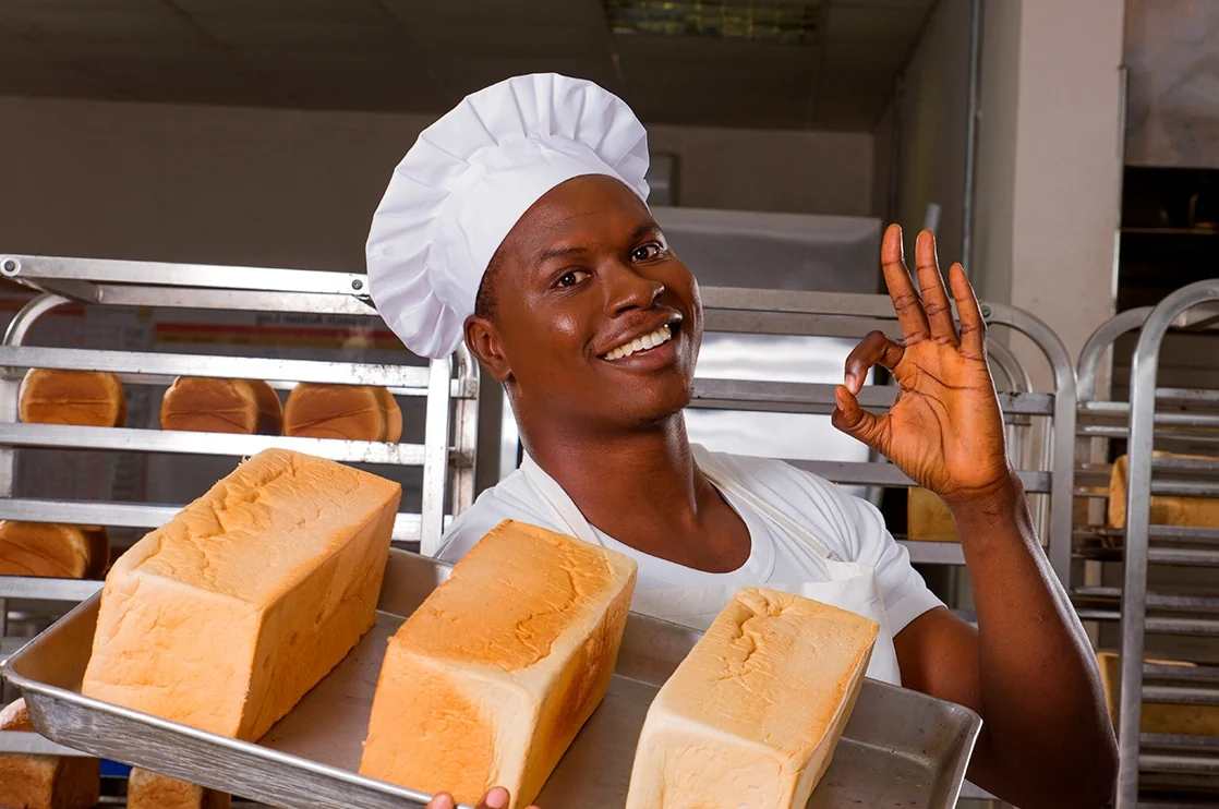 Our baker holding loaves of bread